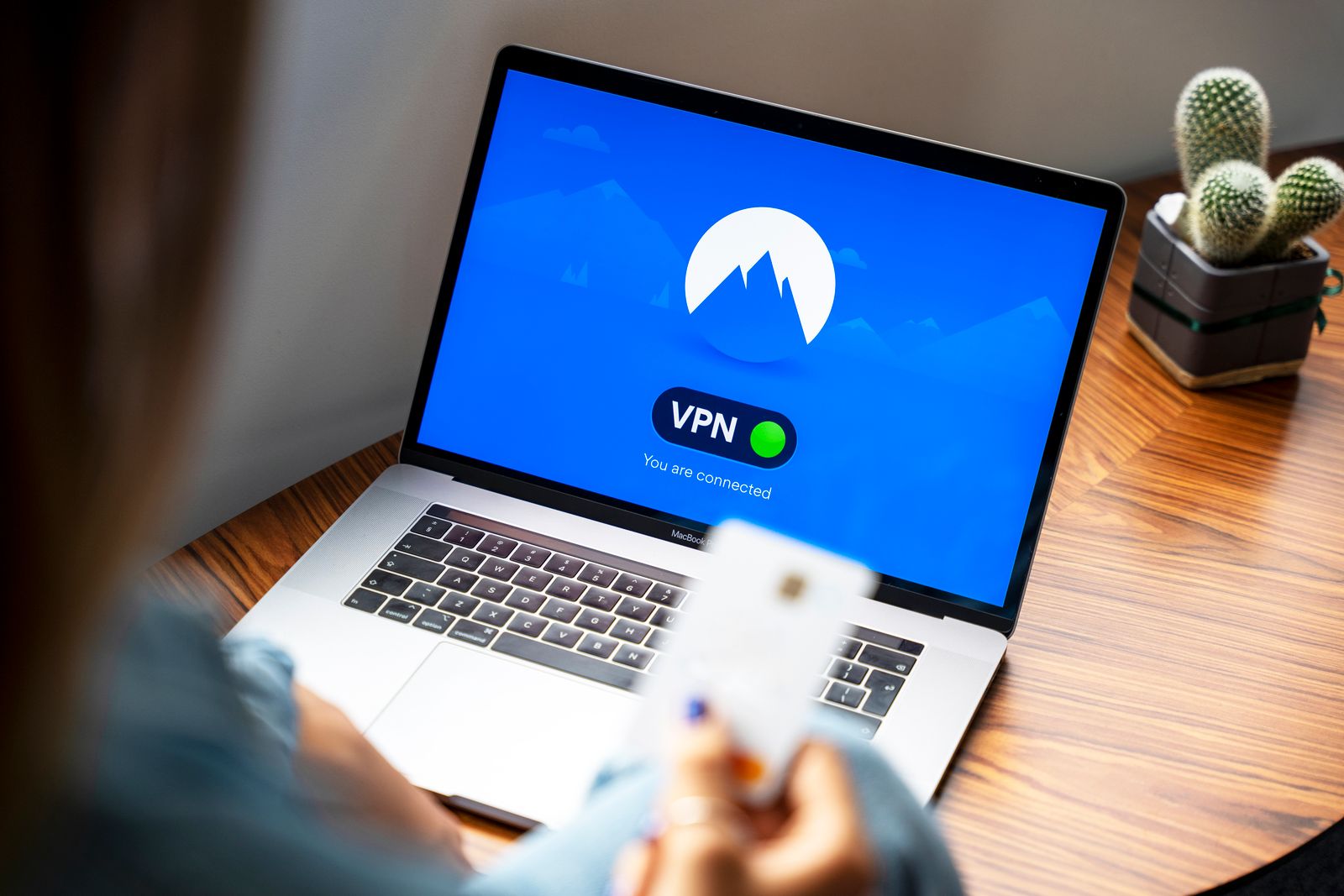 A laptop on a wooden desk displaying an active VPN connection